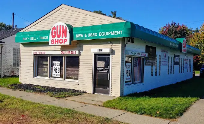 Outside of a gunshop in Westland Michigan. Beige building with green awnings.